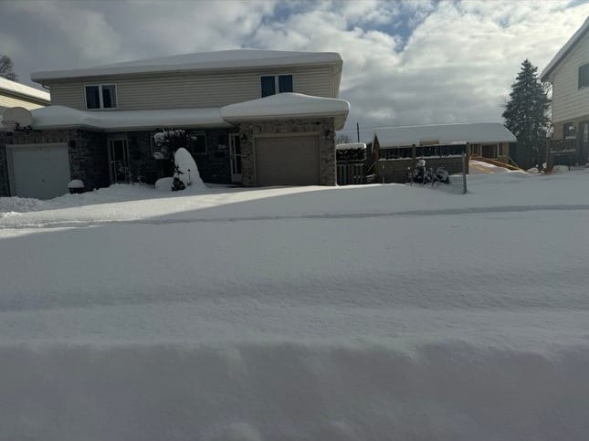 A London property's driveway completely buried under fresh snow, before plowing