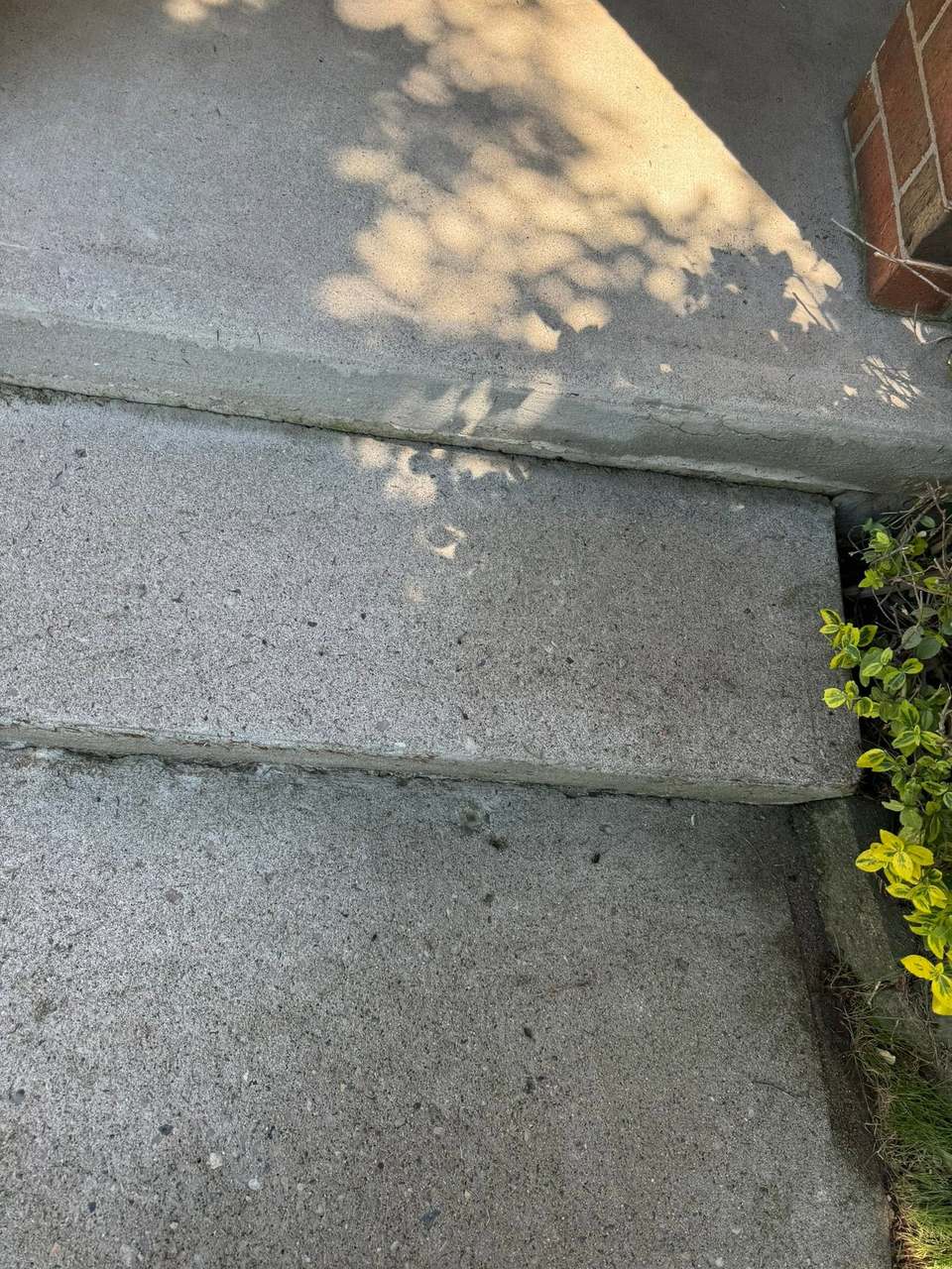 Concrete porch steps washed clean of green algae back to bare grey concrete