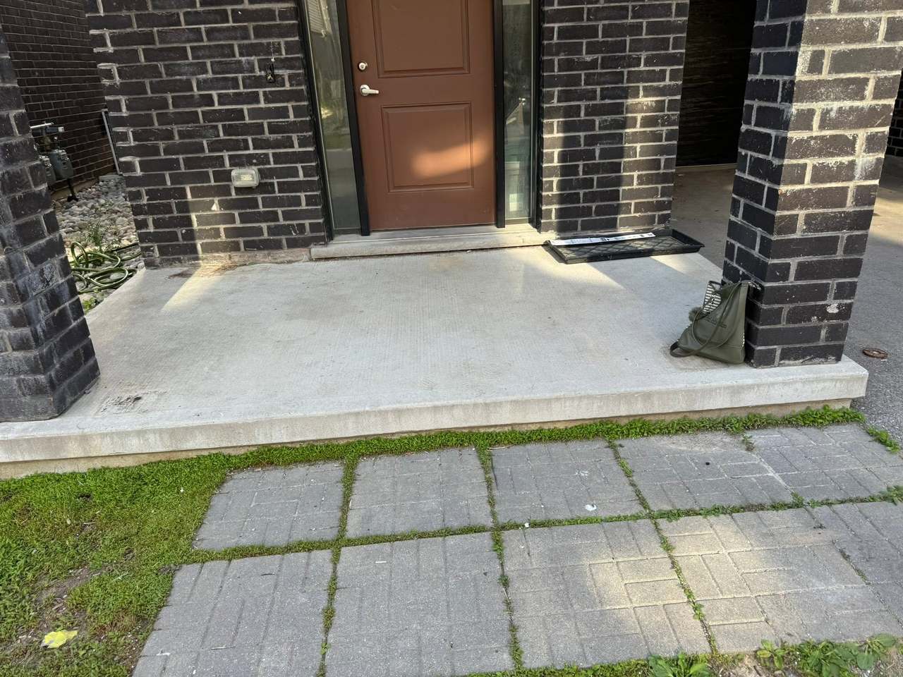 A front stoop cleared of a dollhouse, mattress and bed frame, left swept and empty